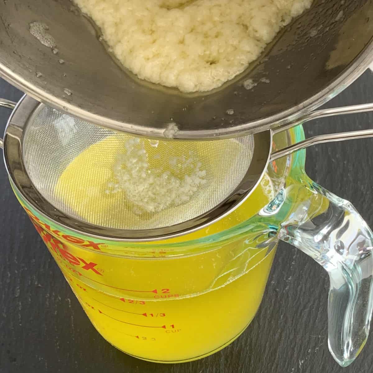 Straining the melted butter through a sieve.