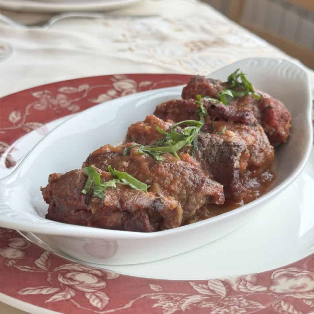 Braciole rolls in a dish with parsley.