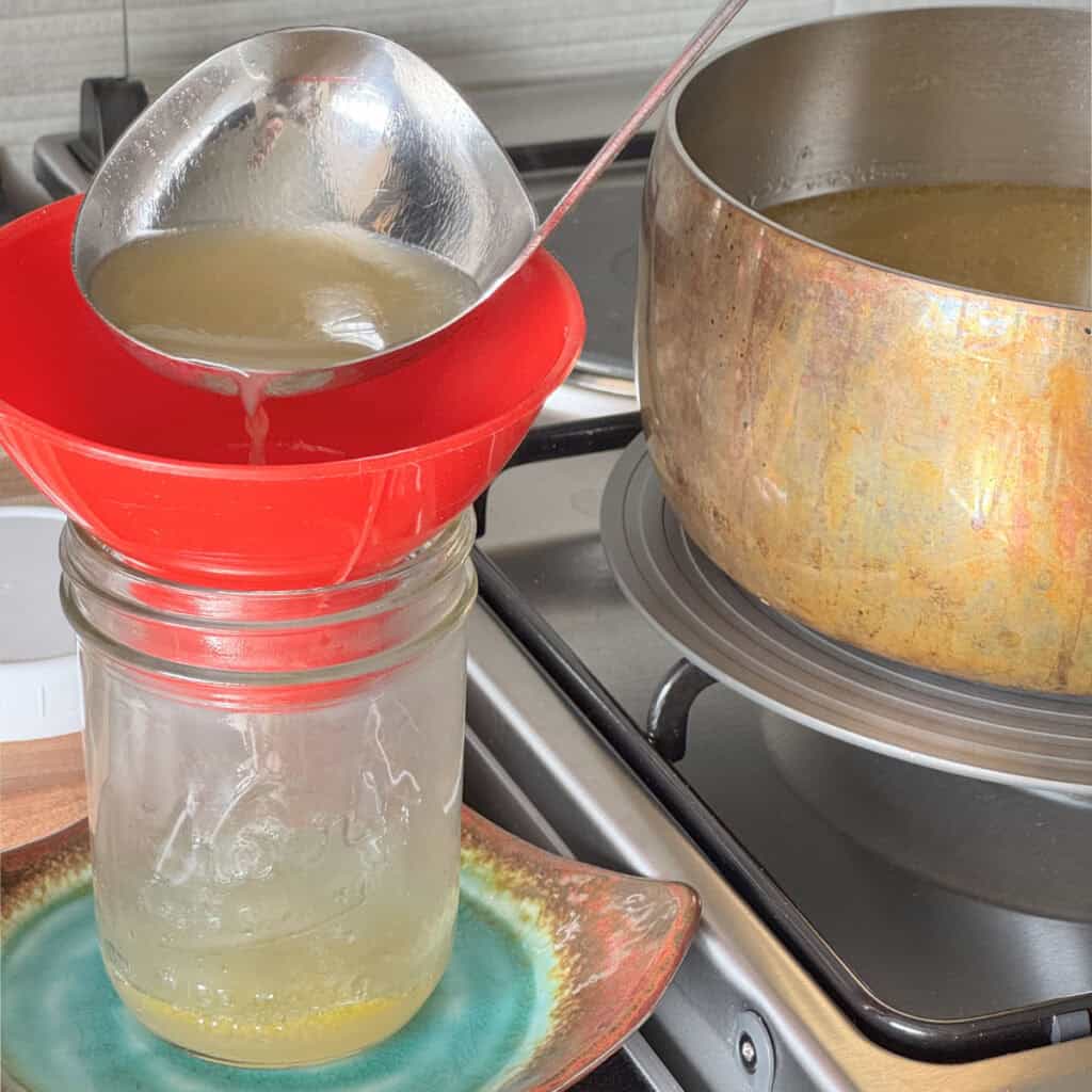 Pouring the broth into a jar.