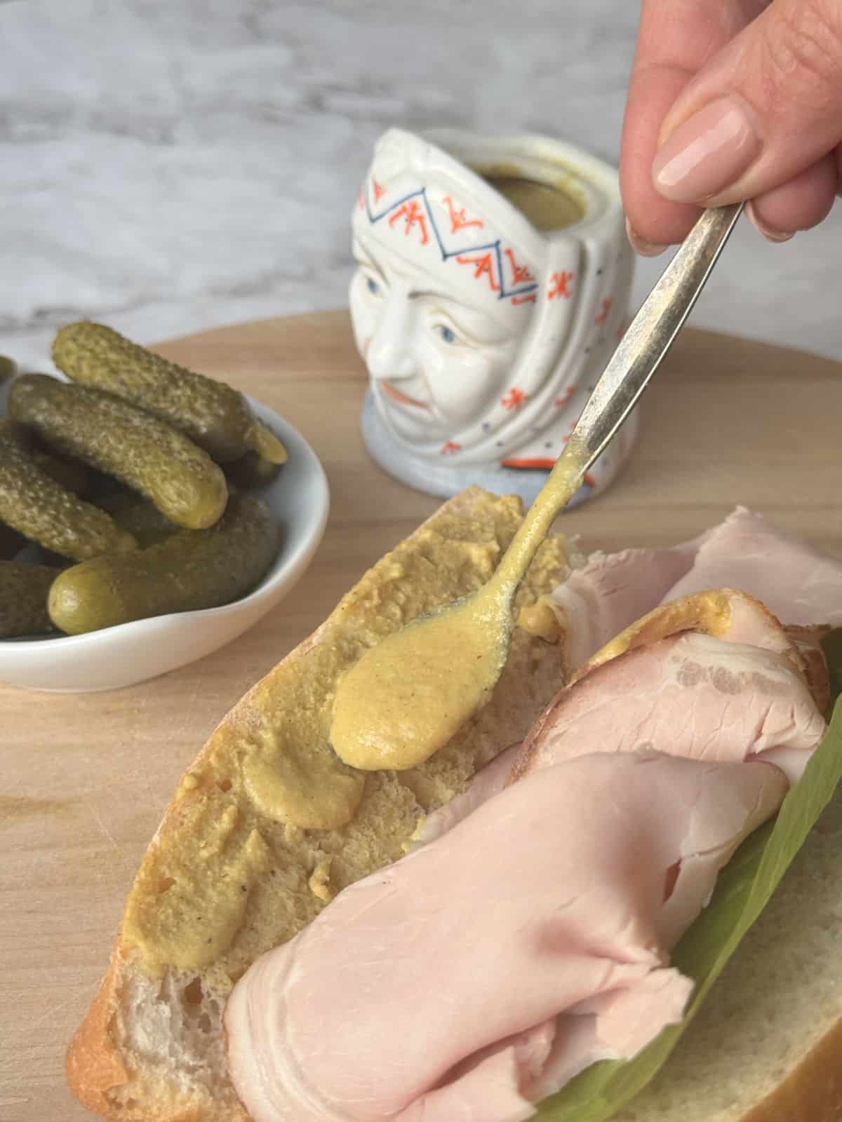 Spoonful of mustard with a ham sandwich.