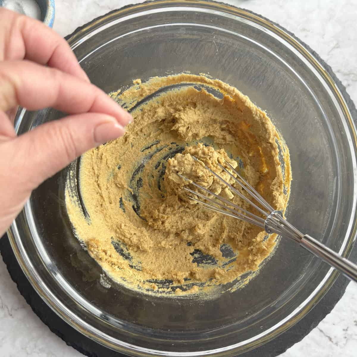Adding seasoning to the mustard.