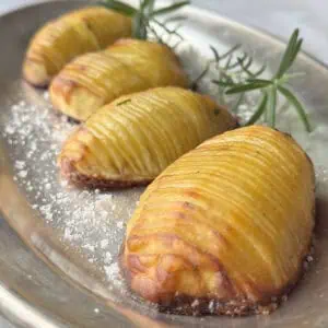 Hasselback potatoes on a silver plate.