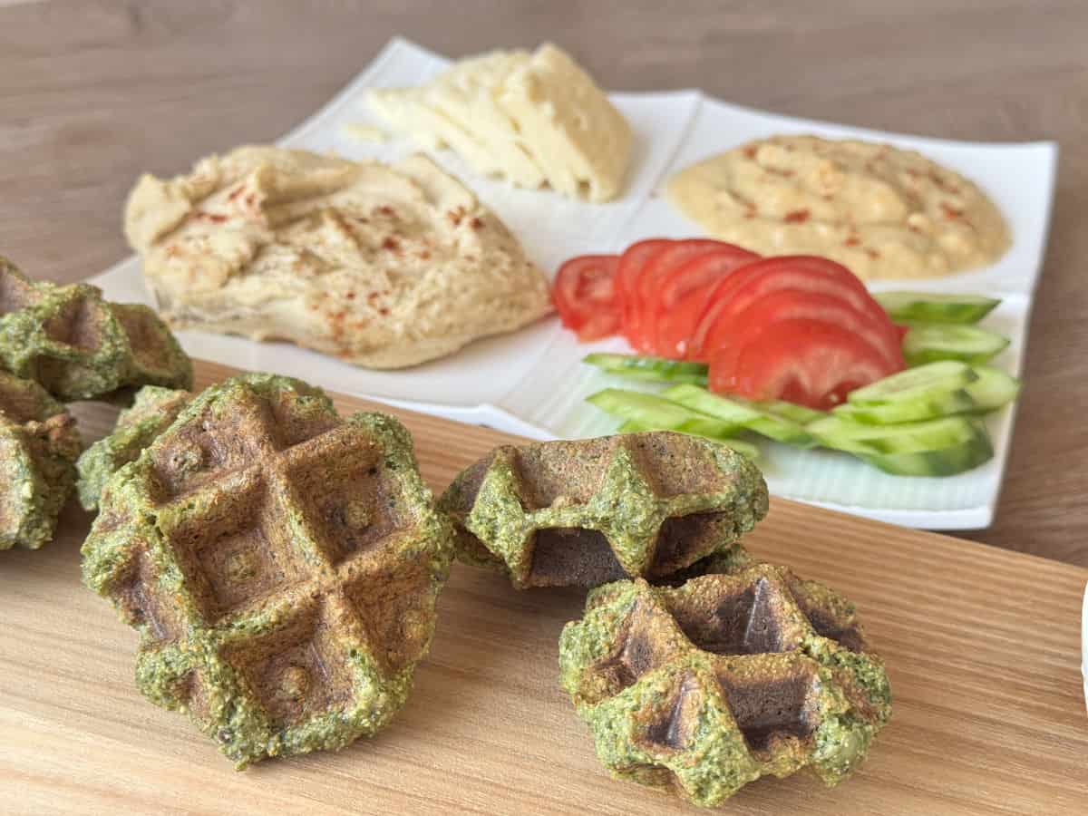 A close-up of falafel waffle on a wooden board.