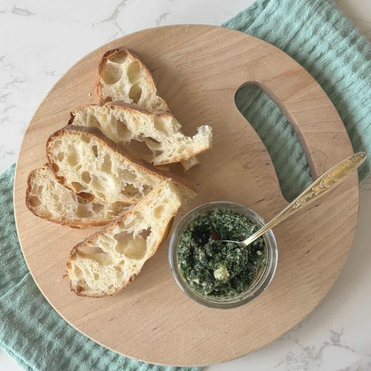 Overhead shot of a toasted bread and a jar of nettle pesto.