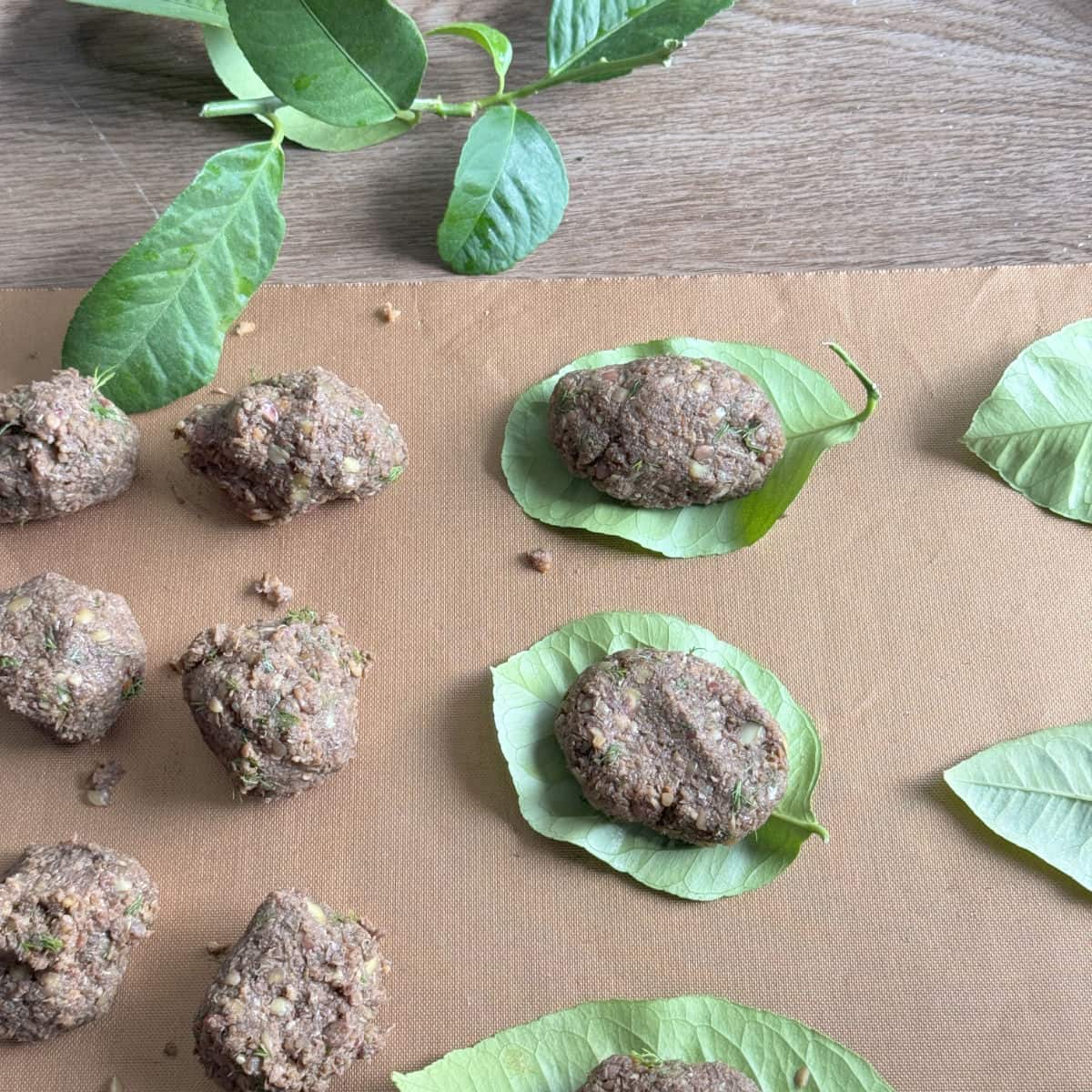 Process of making and wrapping the lentil balls in lemon leaves.