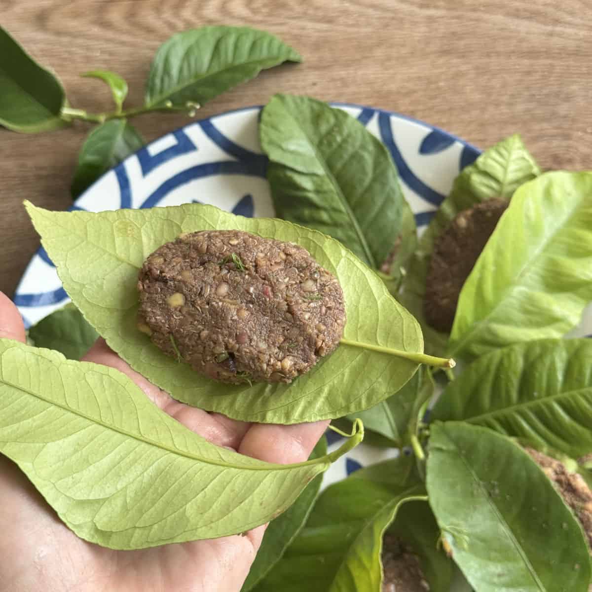 Process of making and wrapping the lentil balls in lemon leaves.