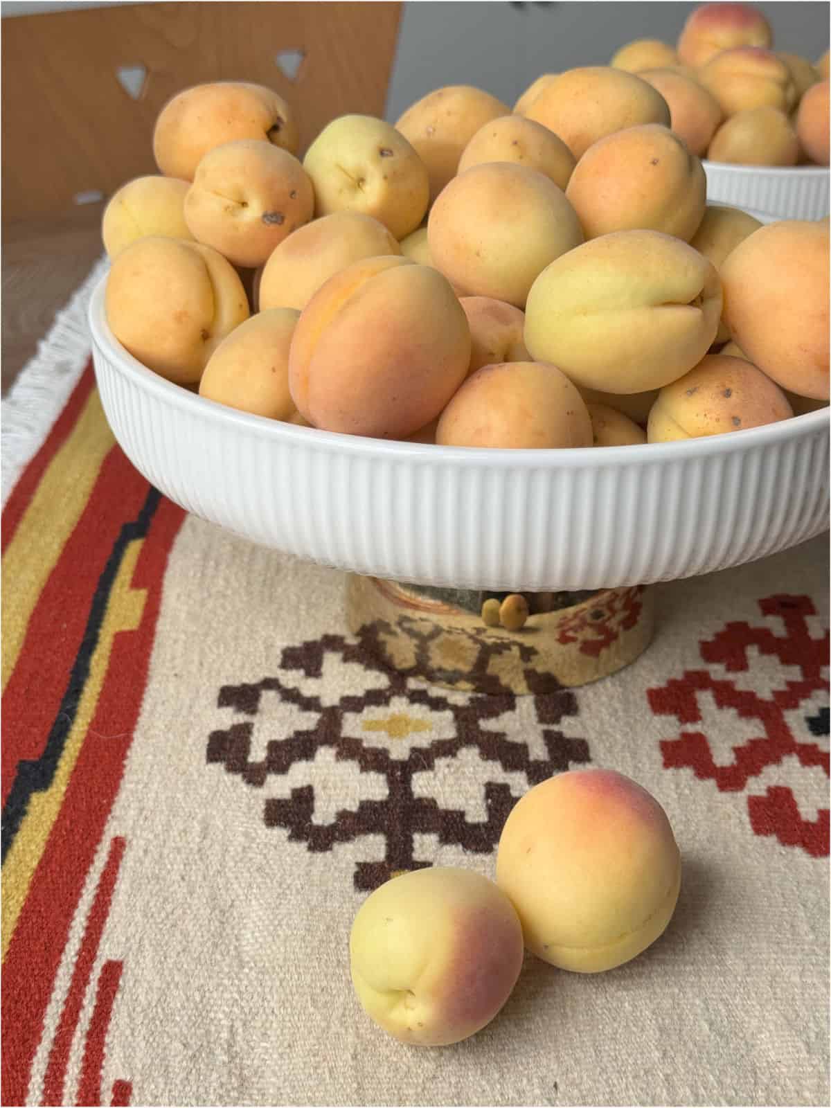 Apricots in a vase on a Armenian carpet.