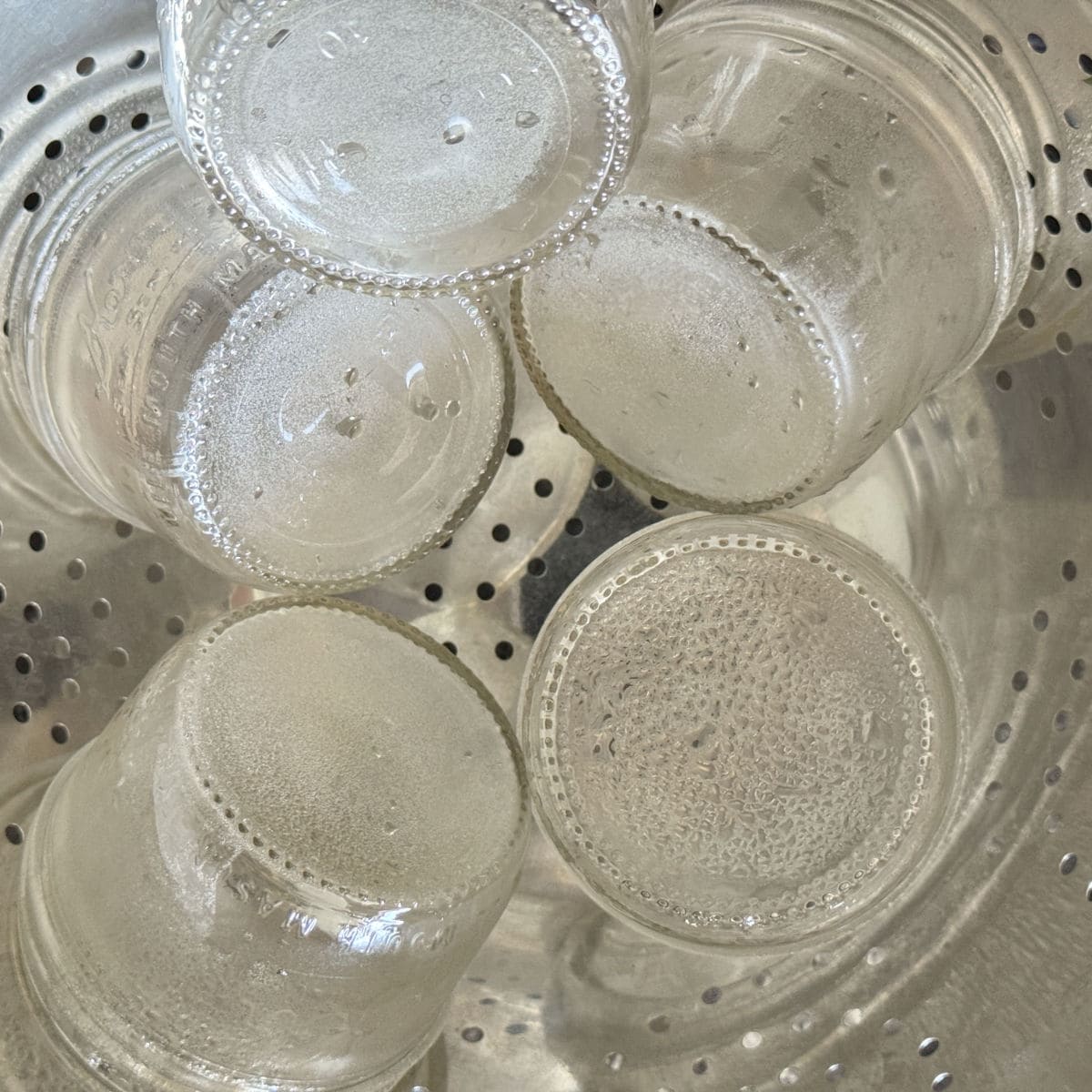 Sterilizing the jars on a big colander.