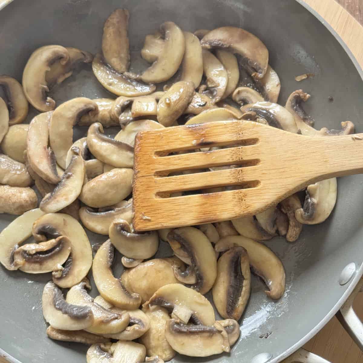 Button mushrooms in a frying pan.