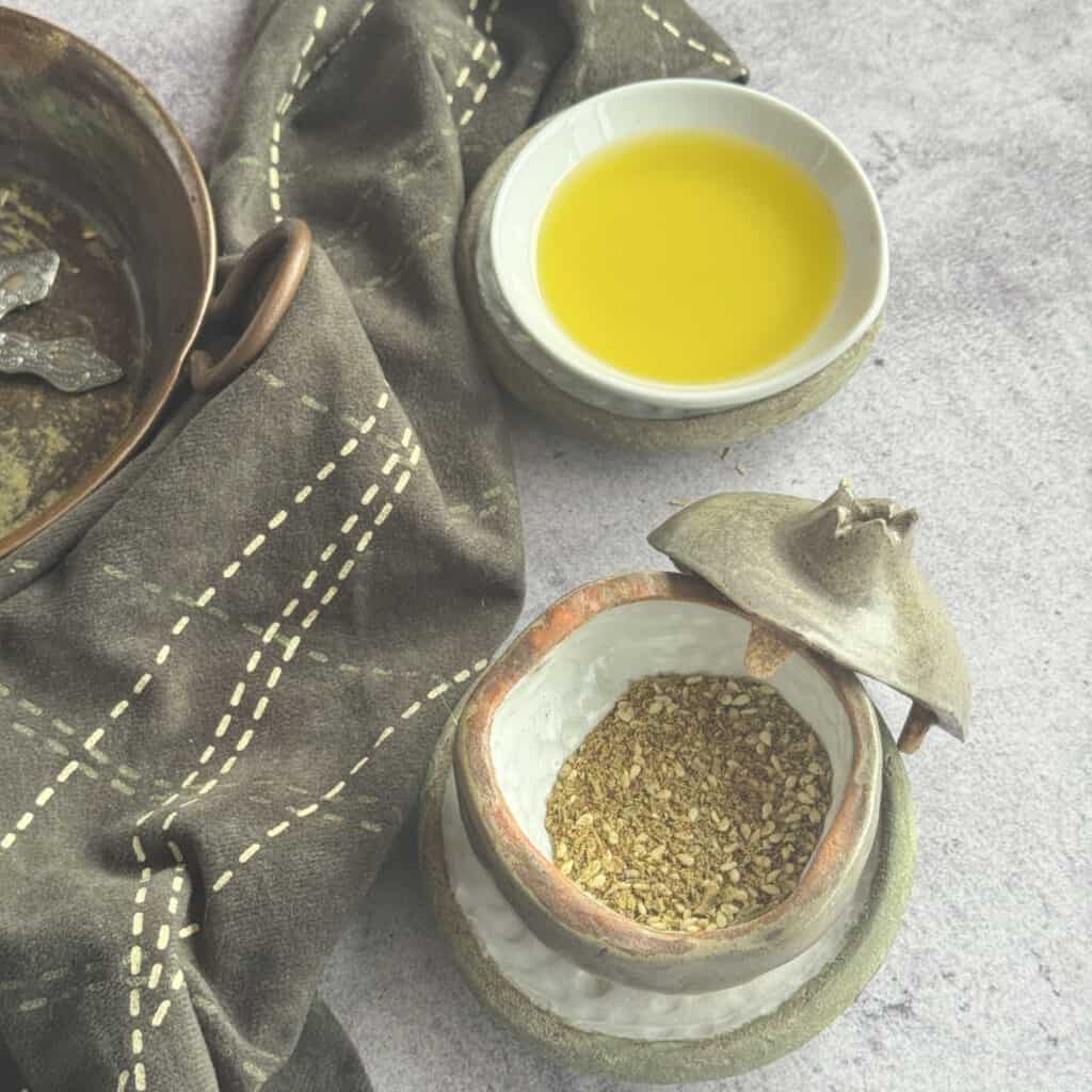 Finished homemade za'atar spice blend in a jar and dish with olive oil.