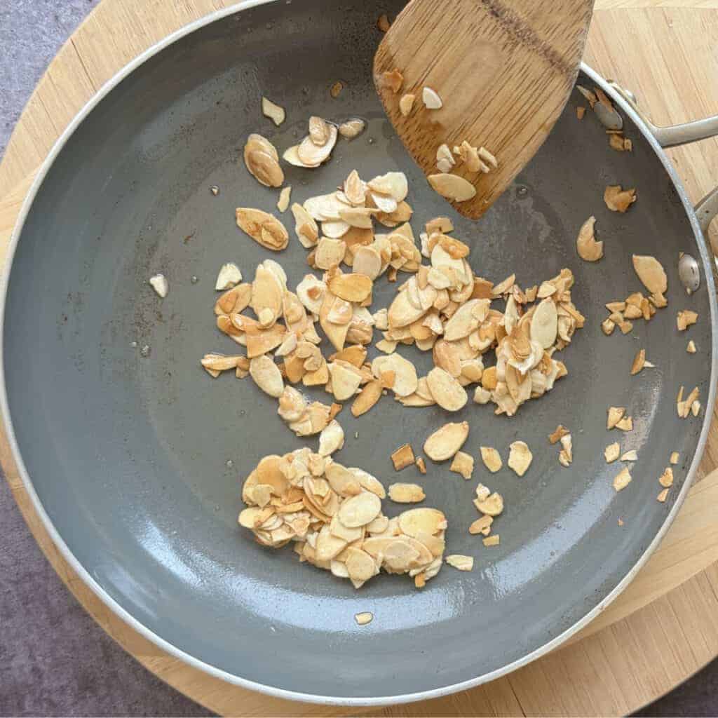 Slivered almonds toasting in butter until lightly golden.