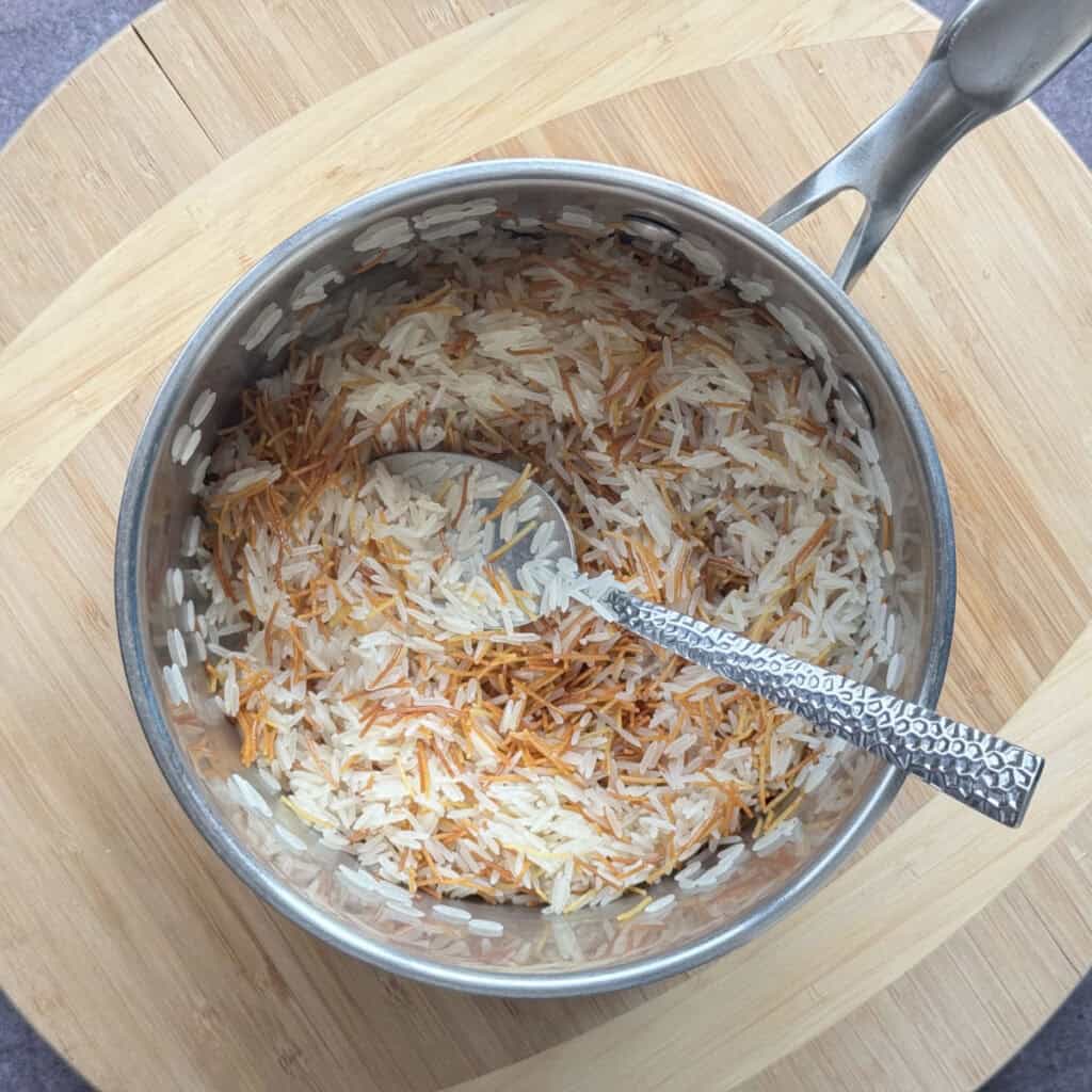 Stirring the rice and toasted pasta together.