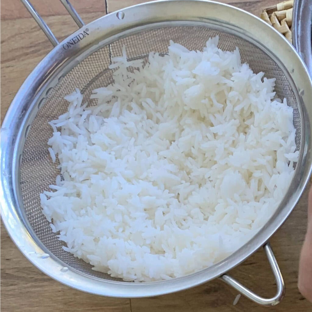 Basmati rice in a metal strainer.