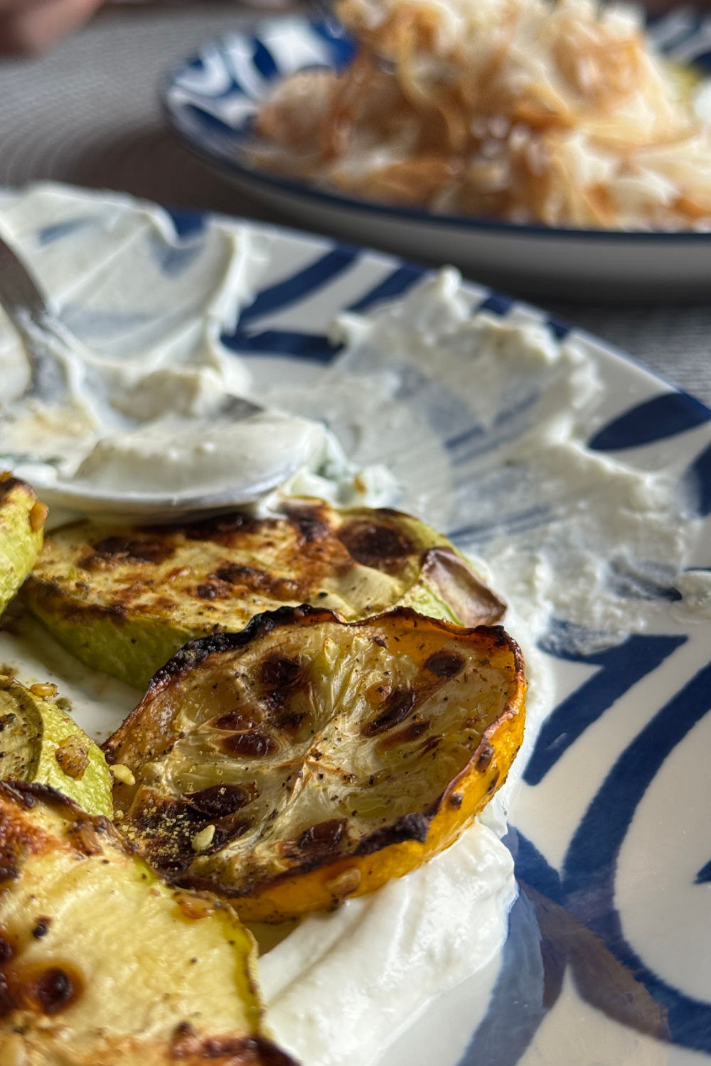 Roasted zucchini plated alongside a pilaf, ready to serve.