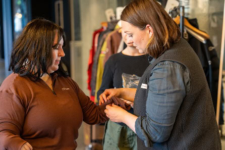 A person helping another person to put on a piece of clothing AI-generated content may be incorrect.