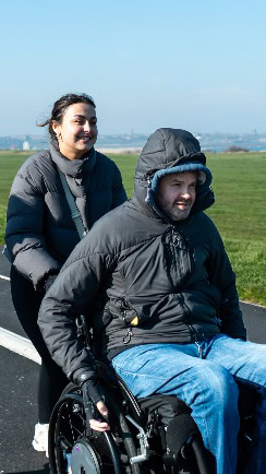 A person pushing a person on a bike AI-generated content may be incorrect.