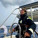 1. Man sailing on a boat during stormy weather in the sea with dark clouds overhead.
