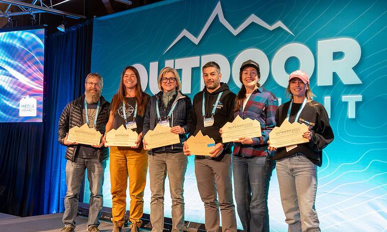 Outdoor awards ceremony with winners holding plaques at Outdoor Insight conference in UK.