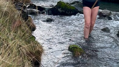 Woman crossing mountain stream at Keswick Mountain Festival 2026.