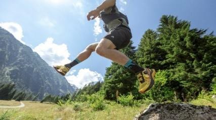 Outdoor adventure activity with a person jumping outdoors in a scenic mountain landscape.