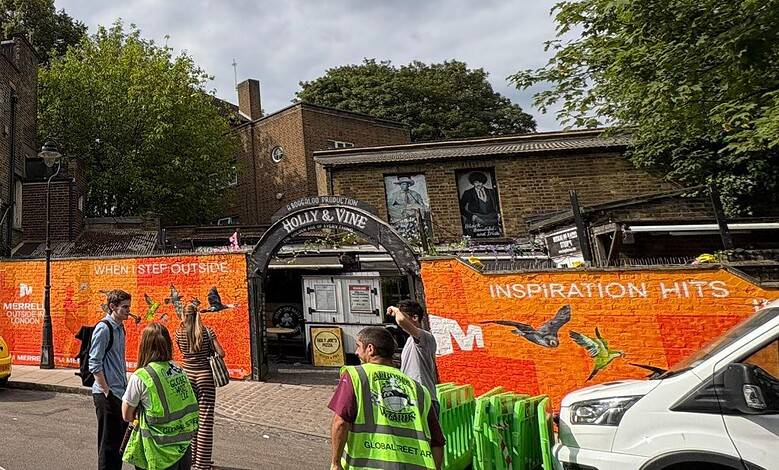 Outdoor mural on a building with people and cars in front, promoting outdoor activities.