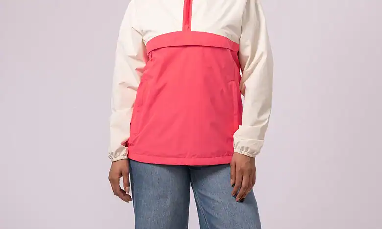 Woman wearing a pink and white outdoor jacket, smiling confidently.