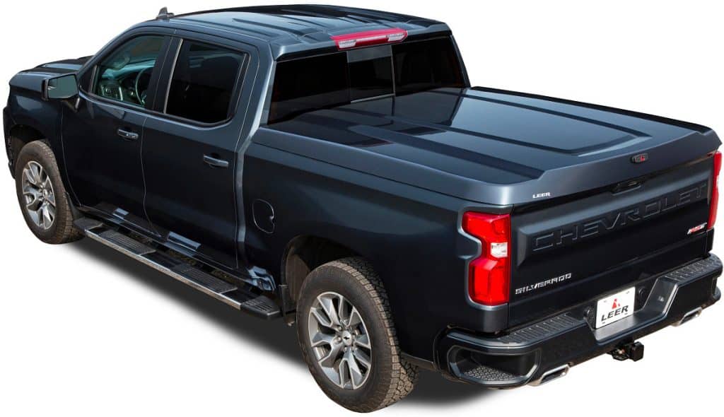 Custom black pickup truck with bed cover and side steps for durability and style.