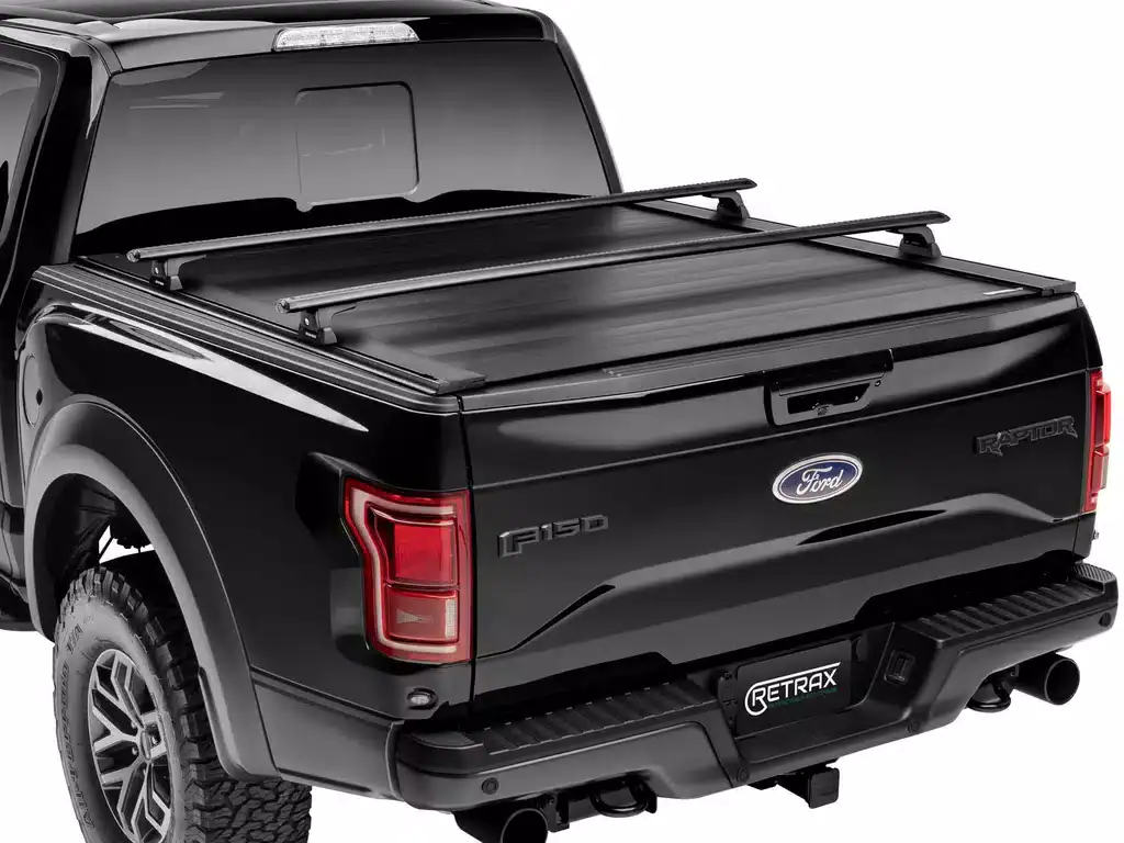 This image shows a black Ford F-150 pickup truck equipped with a Retrax tonneau cover, providing a sleek and secure solution for truck bed protection.