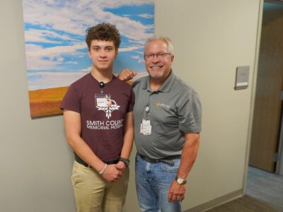 Nex-Gen intern Michael Ferguson poses with Dr. Ferrill Conant outside his office. 