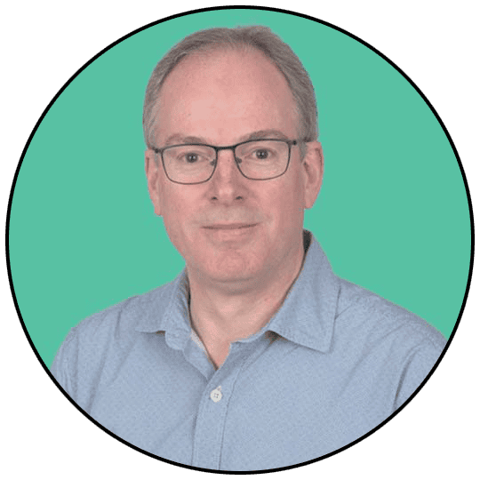 A professional man wearing glasses and a light blue shirt, portrait image.