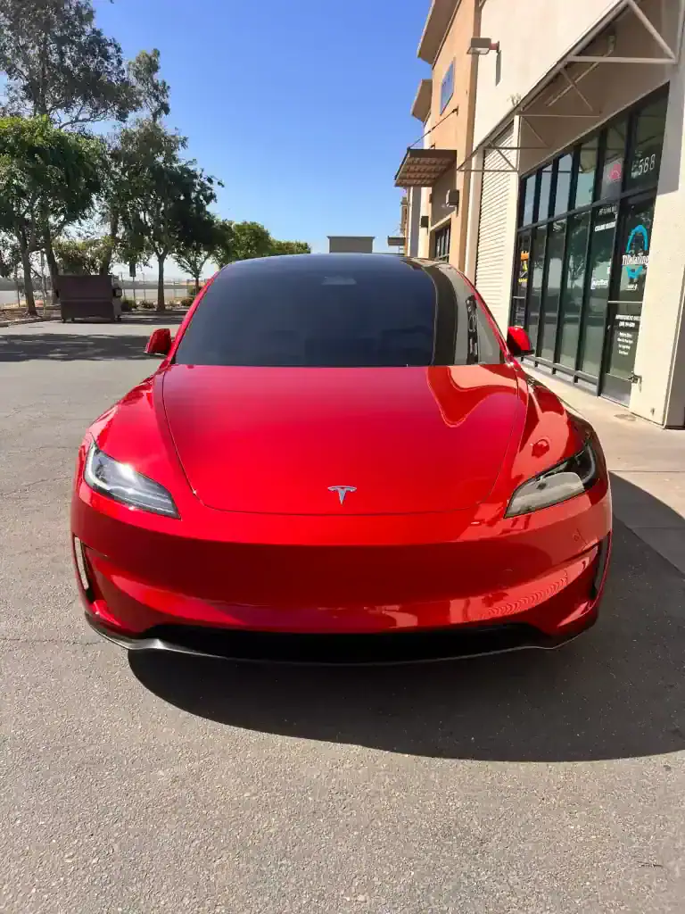 Red Tesla Model S parked outside T1Detailing with shiny finish.