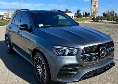 Gray Mercedes-Benz SUV parked outdoors with clear blue sky.