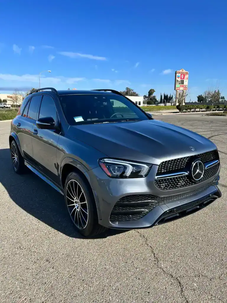 Gray Mercedes-Benz SUV parked outdoors with clear blue sky.