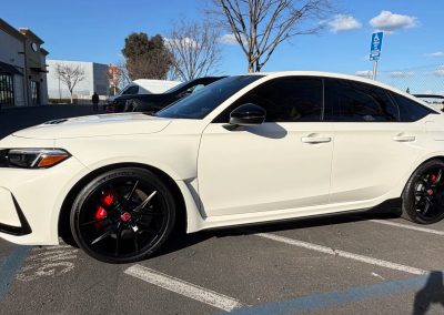 White luxury sedan with black rims and tinted windows at T1Detailing.