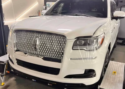 White luxury SUV inside T1Detailing auto detailing shop.