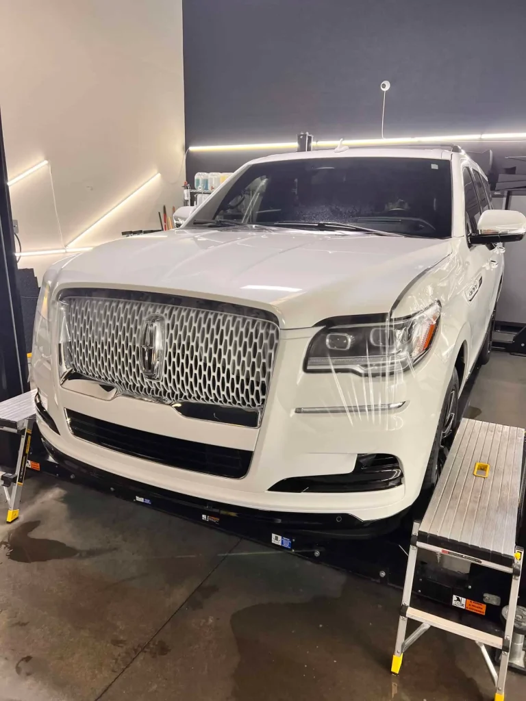 White luxury SUV inside T1Detailing auto detailing shop.