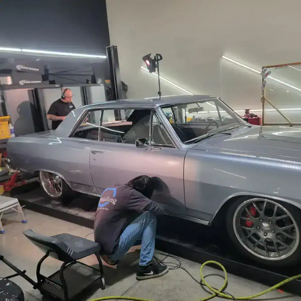 Technician detailing classic silver car
