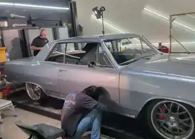 Technician detailing classic silver car