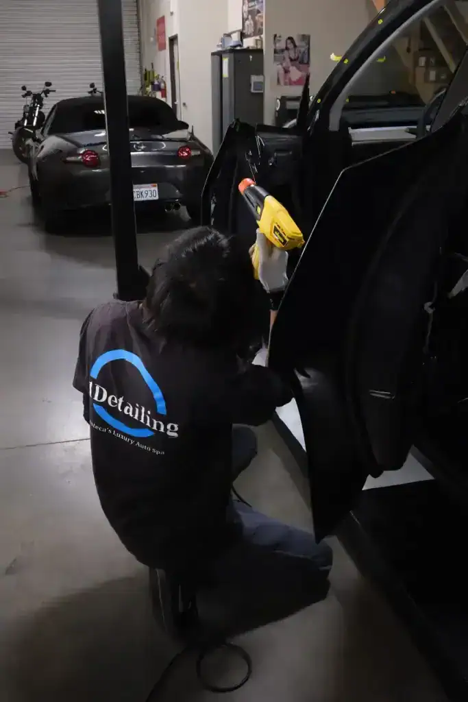 T1Detailing technician working on black vehicle