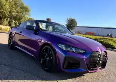 Purple Audi convertible parked outdoors on sunny day.