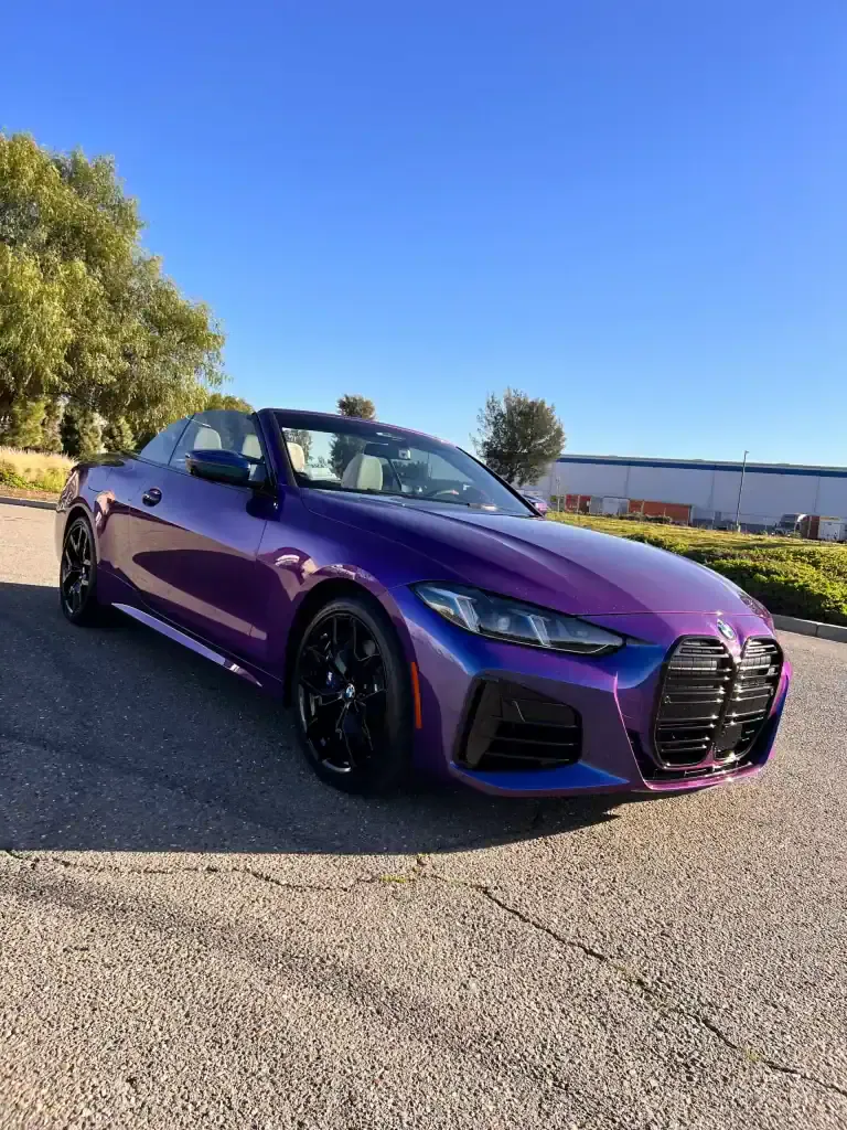 Purple Audi convertible parked outdoors on sunny day.