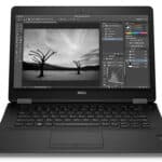 Image of a Dell laptop displaying photo editing software with black and white landscape.