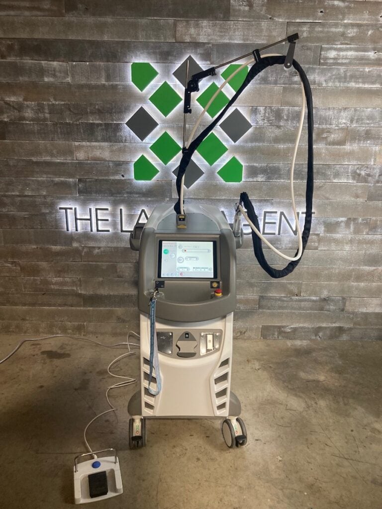 Refurbished 2022 Quanta Evo Light 4V laser device used for aesthetic and medical treatments, featuring a touchscreen interface and adjustable arm, positioned in a professional clinic setting for Sale on The Laser Agent.