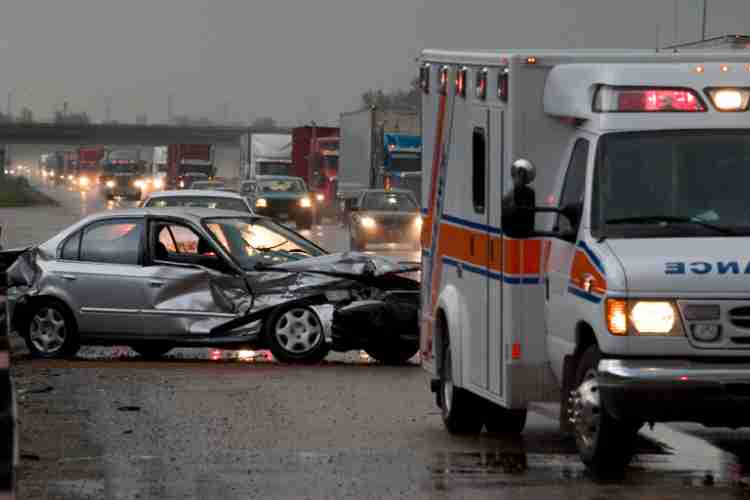 A car accident scene with two cars and a person assessing the damage