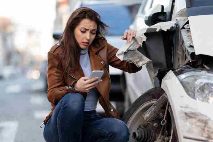 A person taking pictures of the car accident scene