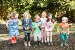 Happy children playing outdoors at Thrive Childcare, fostering early childhood development and social skills in a safe and engaging environment.