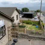 Bright outdoor nursery play area at Thrive Childcare, featuring a secure garden with toys and seating, overlooking a quiet coastal town, ideal for early childhood development and outdoor learning.