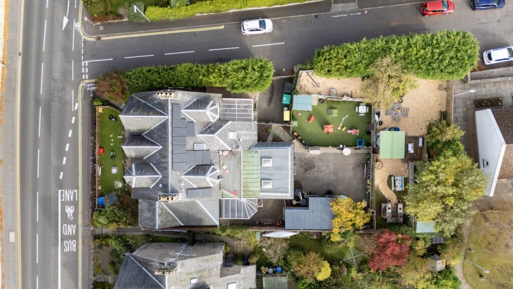 Bright aerial view of Thrive Childcare centre with vibrant outdoor play area, garden, and colourful equipment, illustrating a safe and nurturing environment for children's early education and development.