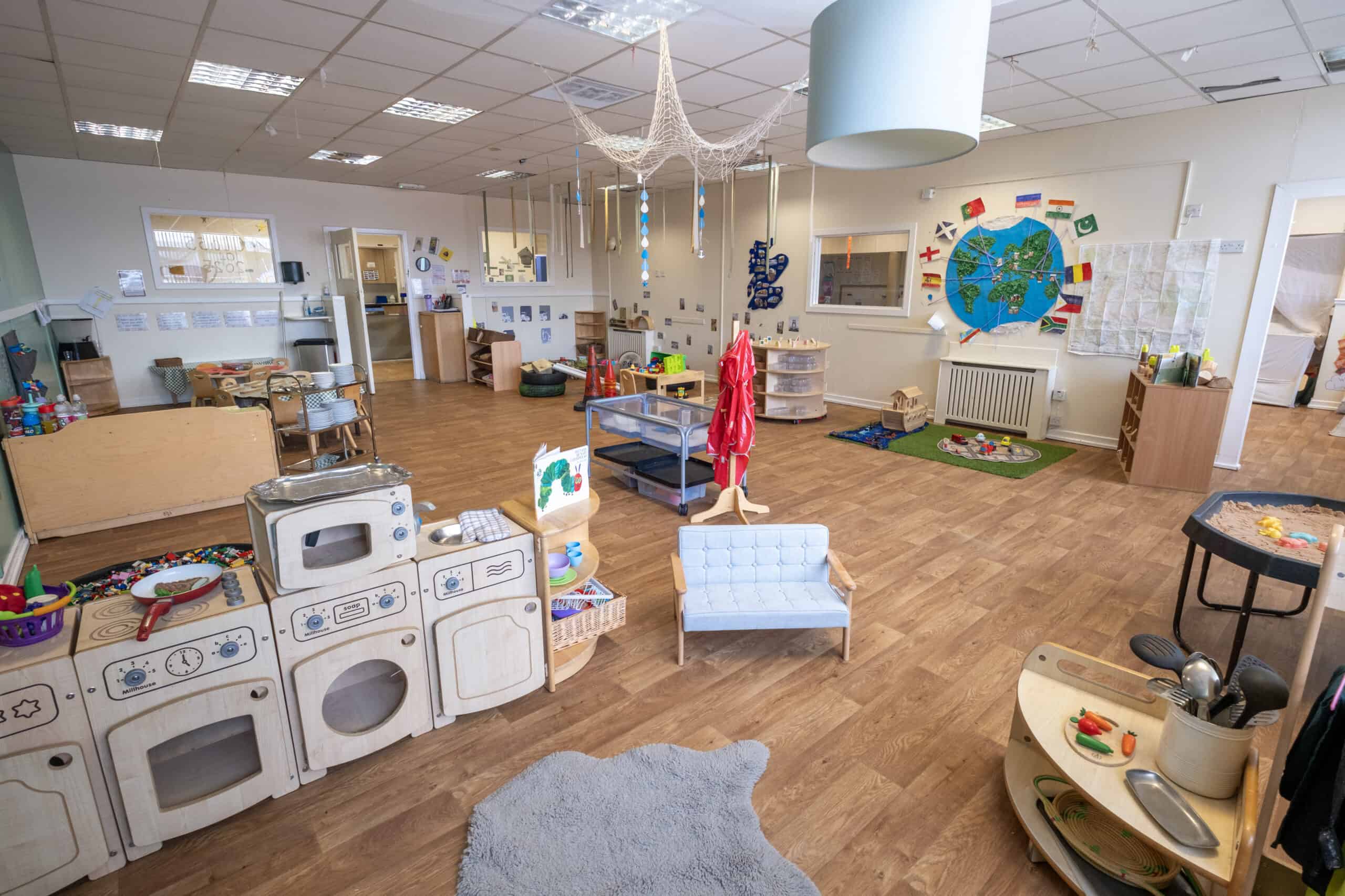 Bright and welcoming childcare playroom with toys, learning stations, and colourful decorations designed for early childhood development at Thrive Childcare.