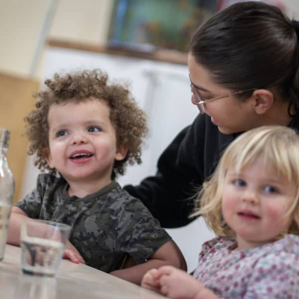 A diverse childcare environment with happy children and caring staff at Thrive Childcare, promoting early childhood development, learning, and nurturing care services in a supportive setting.
